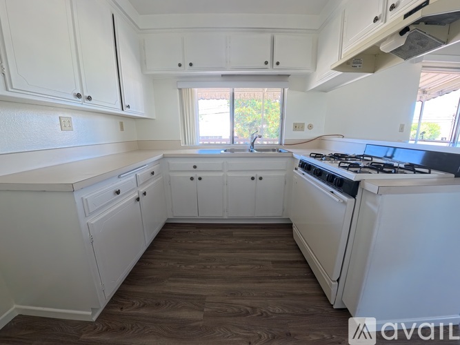 A kitchen with white cabinets and a black stove top oven.