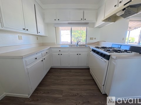 A kitchen with white cabinets and a black stove top oven.