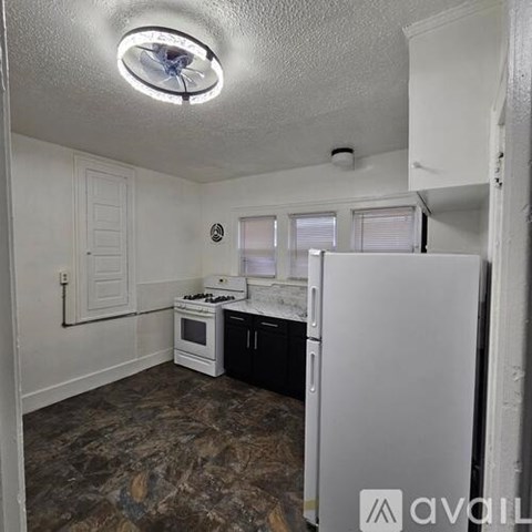 A kitchen with a white refrigerator, stove, and oven.