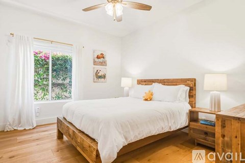 A bedroom with a large bed and a ceiling fan.
