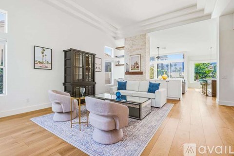 A living room with a white couch and a glass coffee table.