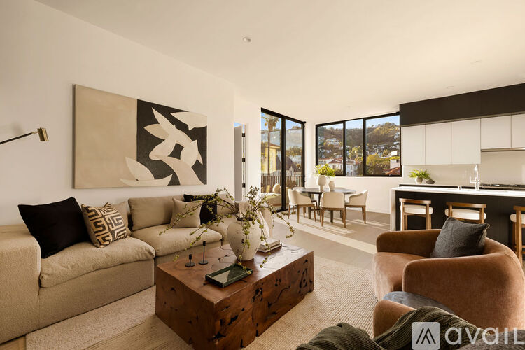 A living room with a beige couch, a coffee table, and a large abstract painting on the wall.