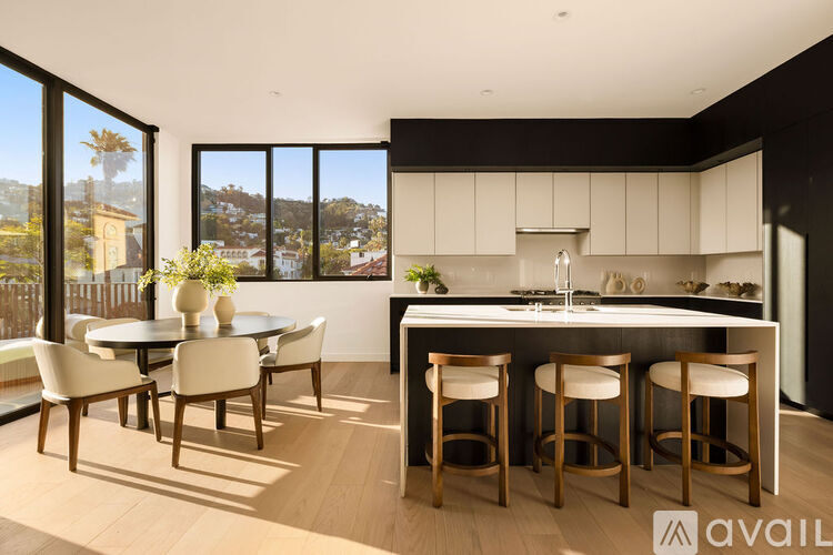 A kitchen with a table and chairs in front of a window.