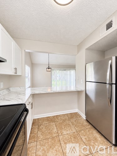 A kitchen with white cabinets and a marble countertop.