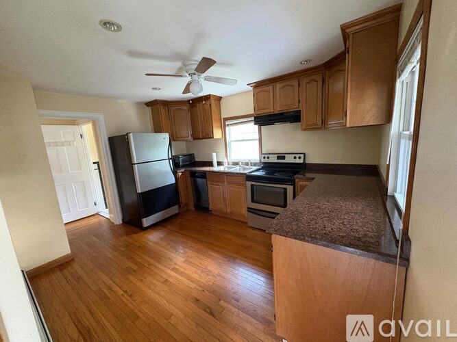 A kitchen with wooden floors and a ceiling fan.