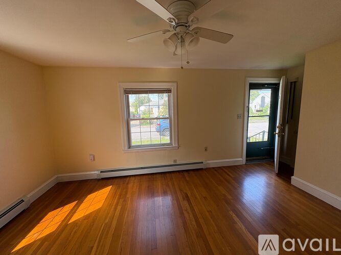 A room with wooden floors and a ceiling fan.