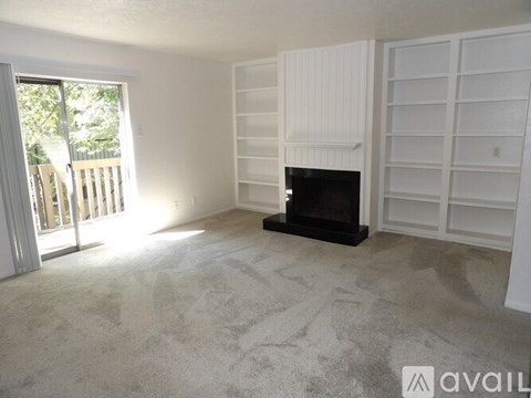 A living room with a fireplace and a carpet.