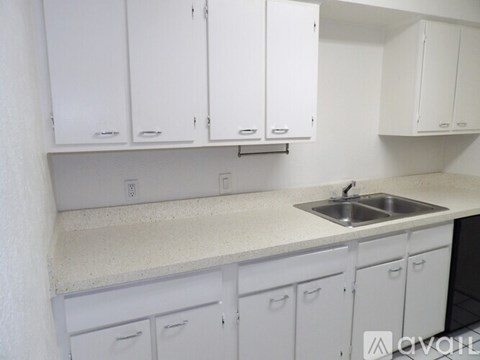 A kitchen with white cabinets and a sink.