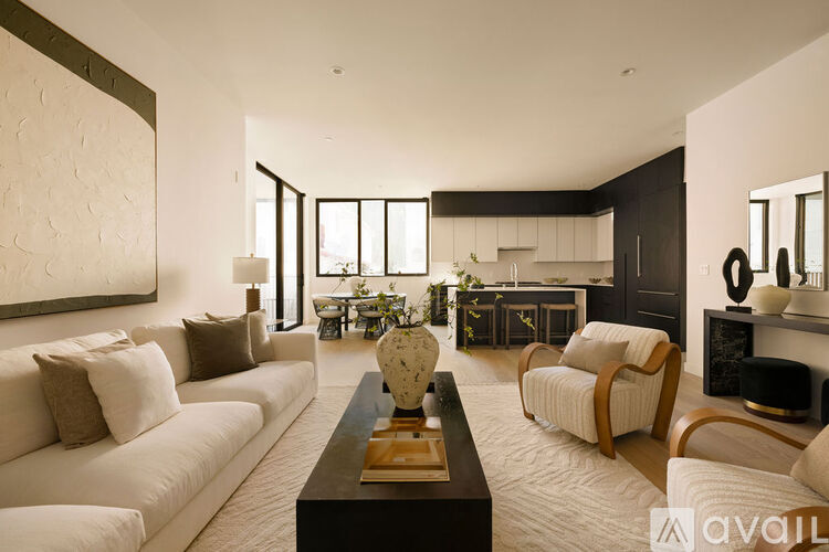 A modern living room with a white sofa and a coffee table in the center.