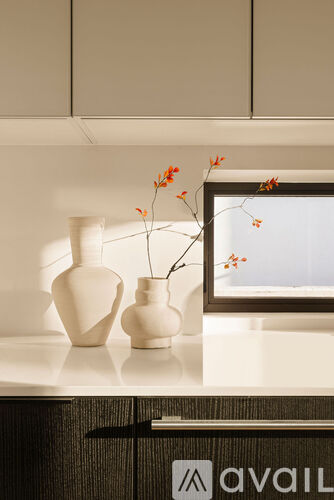 Two vases with flowers in them sit on a counter.