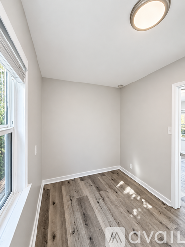 A room with wooden flooring and white walls.