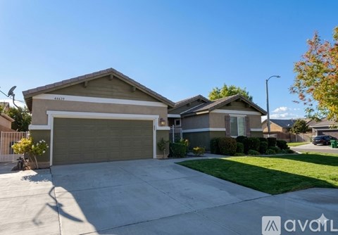 A house with a garage and a driveway in front of it.