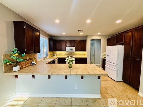 A kitchen with a white fridge and brown cabinets.