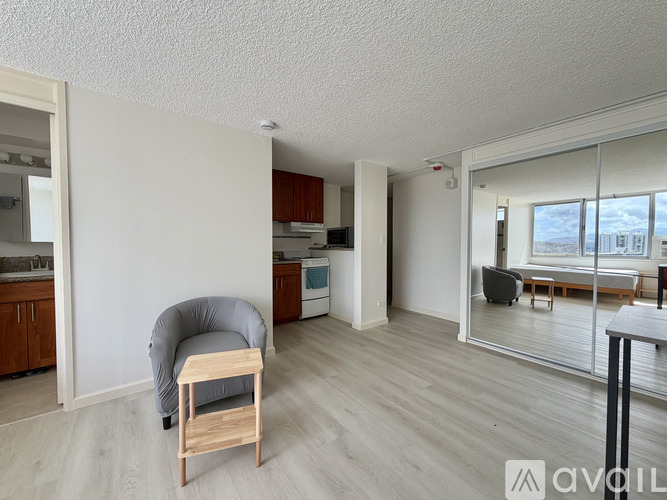 A grey chair with a wooden seat and back is in a room with white walls and wooden flooring.