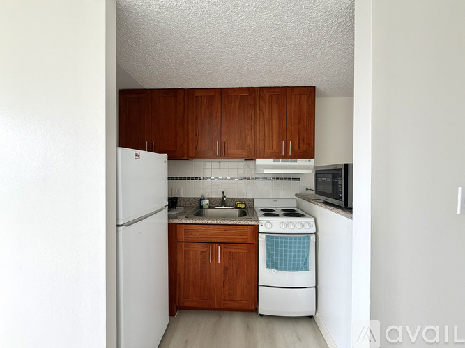 A kitchen with white appliances and wooden cabinets.