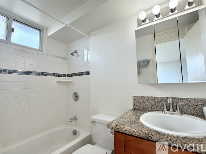 A white bathroom with a tub, toilet, and sink.