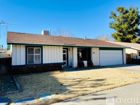A house with a brown roof and white siding is for sale.