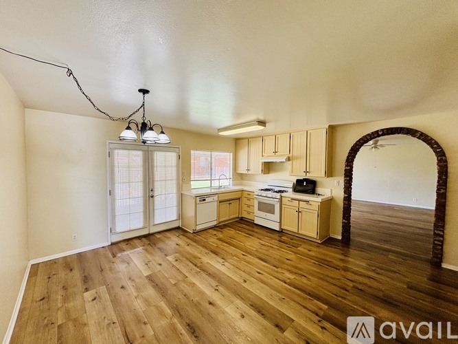 A kitchen with wooden floors and a chandelier.