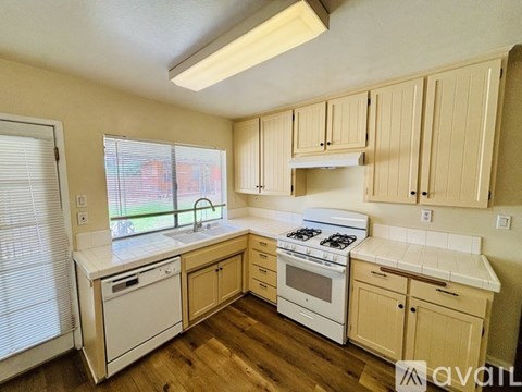 A kitchen with wooden cabinets and white appliances.