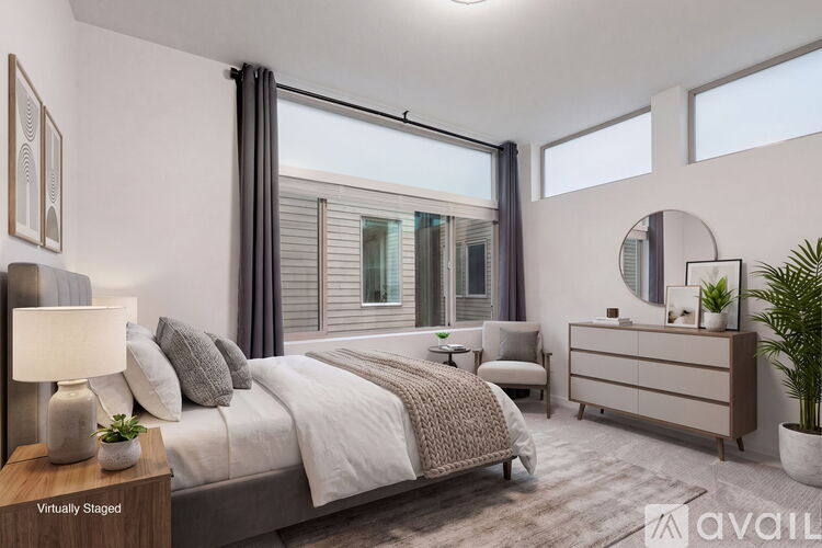 A bedroom with a large bed, a nightstand, and a potted plant.