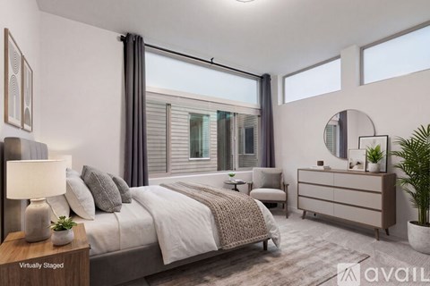 A bedroom with a large bed, a nightstand, and a potted plant.