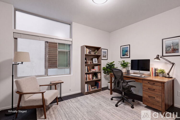 A well-lit office space with a desk, chair, and bookshelf.