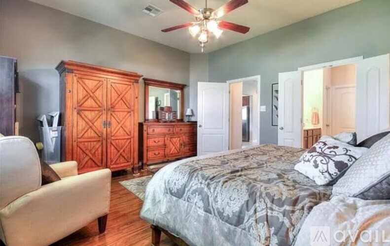 A bedroom with a bed, dresser, and chest of drawers.