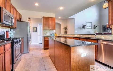 A kitchen with wooden cabinets and a stainless steel refrigerator.