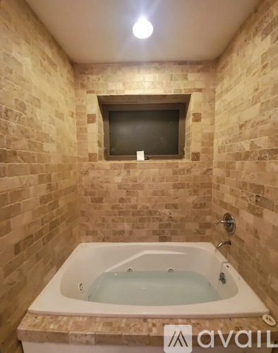 A bathroom with a tub and a window.