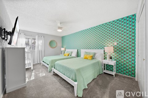 A bedroom with two beds and a television.
