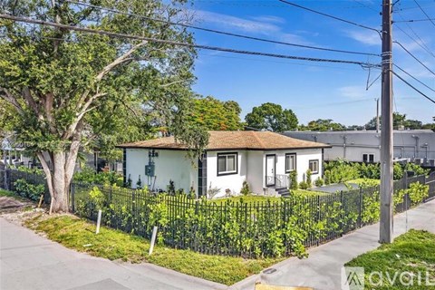 A house with a white exterior and a black fence is for sale.