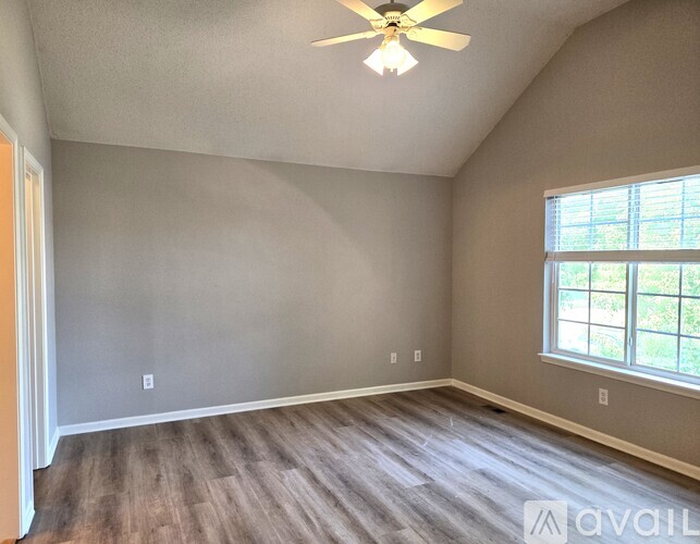 A room with a ceiling fan and a window.