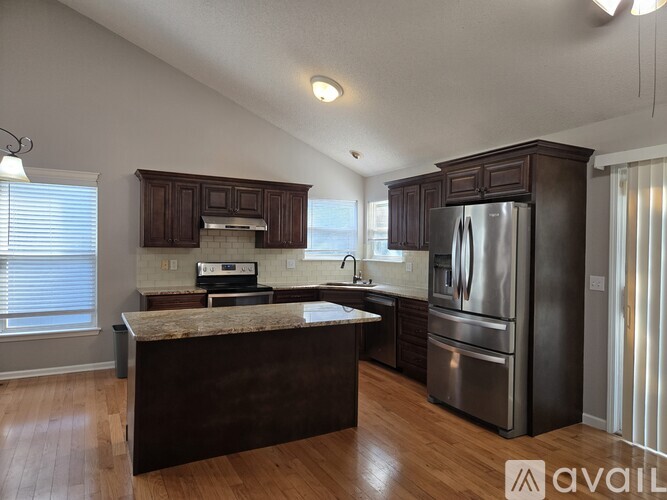 A kitchen with dark wood cabinets and stainless steel appliances.
