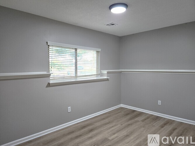 A room with a window and wooden flooring is available.