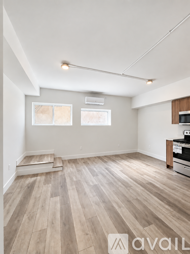 A room with wooden flooring and a wall-mounted TV.
