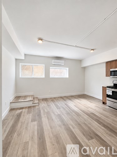 A room with wooden flooring and a wall-mounted TV.