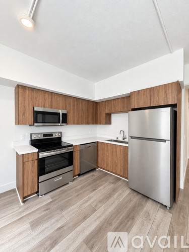 A kitchen with a refrigerator, oven, and microwave.