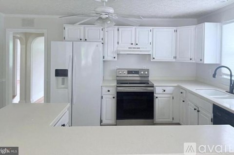 A kitchen with white cabinets and appliances.