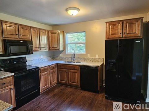 A kitchen with wooden cabinets and black appliances.
