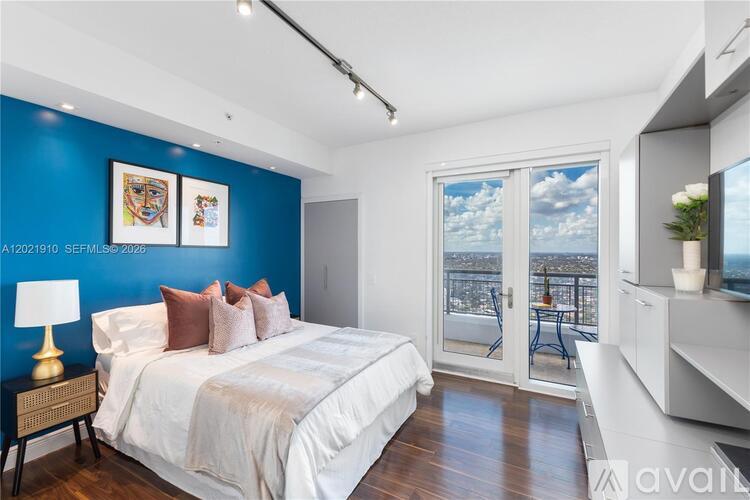 A bedroom with a large bed and a view of the city.