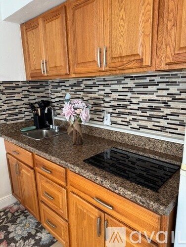 A kitchen with wooden cabinets and a granite countertop.