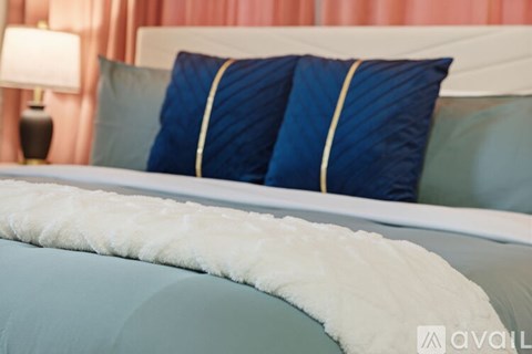 A bed with blue and white bedding and a white headboard.