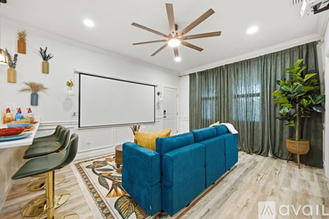 A living room with a blue couch and a whiteboard on the wall.