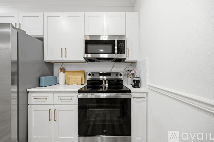A kitchen with white cabinets and a black stove top oven.