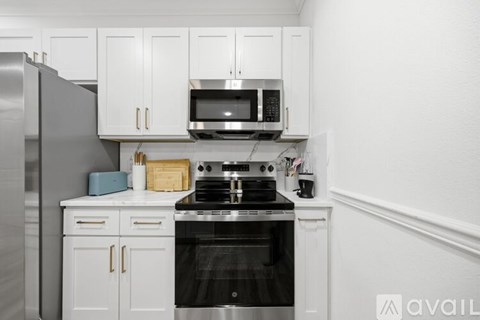 A kitchen with white cabinets and a black stove top oven.