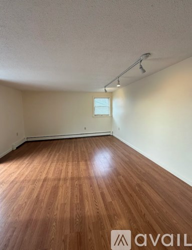 A room with wooden flooring and a window.