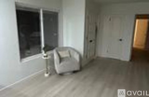 A room with a white chair and a white couch.