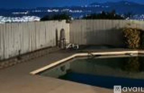 A pool with a wooden fence and a chair.