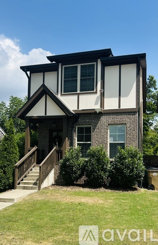 A house with a black roof and a white front porch.