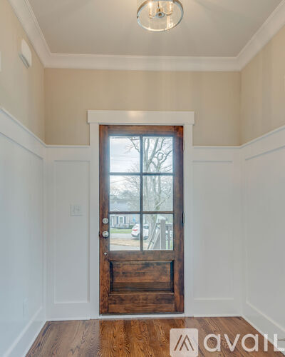 A room with a wooden floor and a large wooden door leading to a balcony.